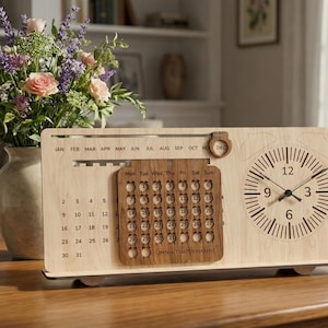 May include: A wooden desk calendar and clock. The calendar has a monthly layout with individual date markers. A clock with a minimalist design is integrated on the right. The text "OMNIA TEMPUS HABENT" is visible on the calendar.