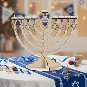 May include: A wooden menorah with nine candle holders, featuring Star of David cutouts. The menorah is on a table with a blue and white Star of David runner, surrounded by dreidels and gold coins. White candles are in the holders.