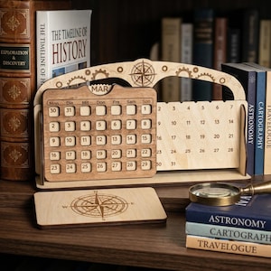 May include: Wooden perpetual calendar with a compass design, gears, and the month of March displayed. The calendar includes a separate base with a compass rose design. Books and a magnifying glass are in the background.