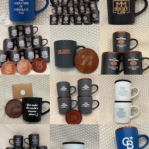 May include: Collection of ceramic mugs with various designs and text, including "The Godfather of Corporate Tax," "MM Injury Law," and "Oak Pilates." Some mugs have wooden lids and matching coasters. Colors include blue, black, white, and gray.