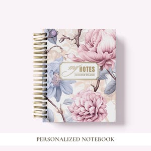 May include: A spiral-bound notebook featuring a floral pattern with large pink and light blue flowers on a white background. A central rectangular label contains the gold text "my NOTES" above the name "JENNIFER WILSON" in a gold frame.