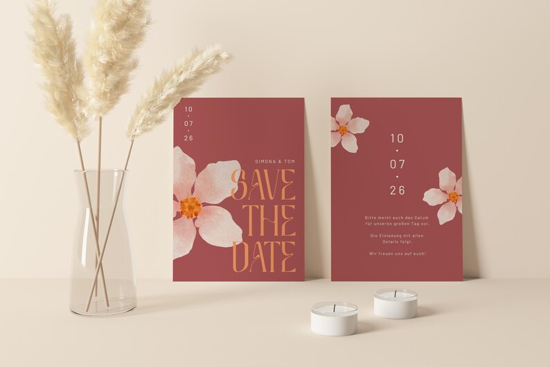 May include: Two red save the date cards with white floral designs and the text "Save the Date" in orange. The date is 10.07.26.