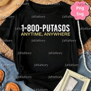 May include: Black t-shirt with the text "1-800-PUTASOS ANYTIME, ANYWHERE" in white and yellow. The shirt is displayed on a denim background with a pearl necklace and a framed picture.