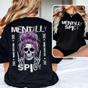 a woman wearing a black t-shirt with a graphic design of a skull wearing a purple bun and the text "Mentally Spicy" printed on it.