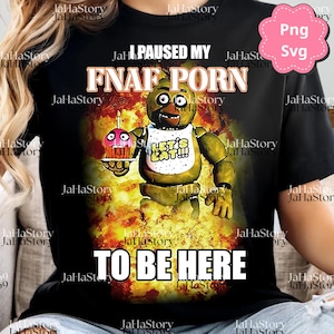 Puede incluir: Camiseta negra con un gráfico de un personaje animatrónico amarillo sosteniendo una magdalena. El texto en la camiseta dice "I PAUSED MY FNAF PORN TO BE HERE". El personaje lleva un babero que dice "LET'S EAT!!!".