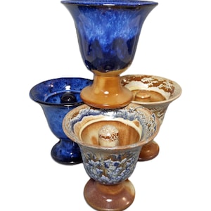 May include: Three ceramic vases with blue and brown glaze. The top vase is a tall, slender cup shape. The middle vase is a wide, shallow bowl. The bottom vase is a smaller, round cup shape.