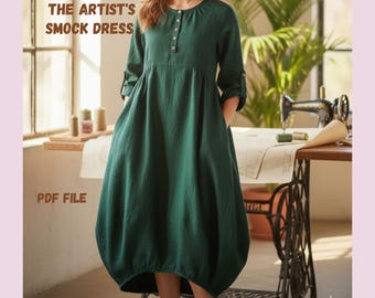 May include: A dark green linen smock dress with a round neckline and button details. The dress has long sleeves that are rolled up at the elbows and pockets. The text on the image reads "THE ARTIST'S SMOCK DRESS", "PDF FILE", and "EFFORTLESS LINEN COMFORT".