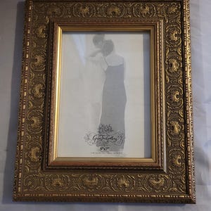 May include: Ornate gold-colored picture frame with a detailed, embossed design. The frame holds a black and white photo. The frame is 5" x 7". The text "Green Tree Gallery" is visible.