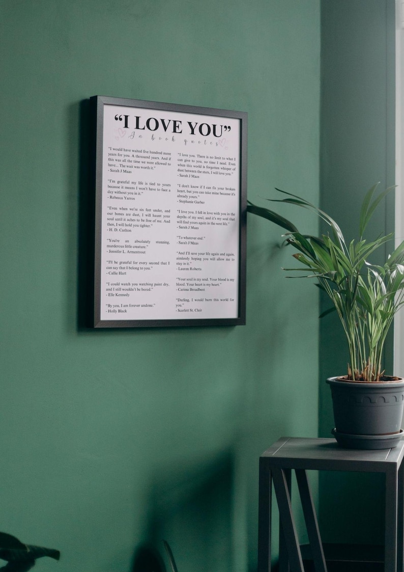 K&ouml;nnte beinhalten: Ein schwarzer gerahmter Druck mit dem Text "I Love You" in wei&szlig;en Buchstaben. Der Druck zeigt eine Sammlung von Zitaten &uuml;ber die Liebe von verschiedenen Autoren und Dichtern.