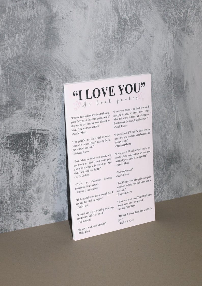 K&ouml;nnte beinhalten: Eine wei&szlig;e Karte mit rosa Herzen und schwarzem Text, der "I LOVE YOU" in Buchzitaten lautet. Die Karte enth&auml;lt Zitate &uuml;ber die Liebe aus verschiedenen B&uuml;chern und Autoren.