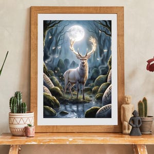 Op de afbeelding: Een ingelijste kunstdruk toont een witte hert met gloeiende geweien in een maanverlicht bos. Het kunstwerk toont een sereen landschap met een beek, met mos bedekte rotsen en een volle maan.