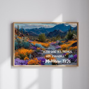 May include: A framed print of a desert landscape with mountains in the background. The foreground features a path through colorful wildflowers. The text "WITH GOD ALL THINGS ARE POSSIBLE" and "Matthew 19:26" is displayed.