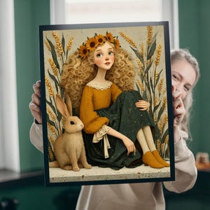 May include: A framed art print featuring a whimsical illustration of a young person with curly blonde hair wearing a sunflower crown and mustard-colored dress. A brown rabbit sits beside them. The background includes wheat stalks.