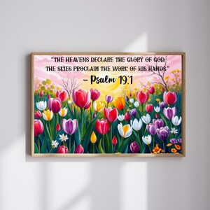 Puede incluir: Una impresión enmarcada que presenta un campo vibrante de tulipanes en tonos rojos, rosas, amarillos y morados. La obra de arte incluye el texto "THE HEAVENS DECLARE THE GLORY OF GOD, THE SKIES PROCLAIM THE WORK OF HIS HANDS." y "Psalm 19:1".
