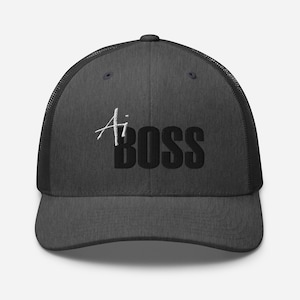 May include: Dark gray trucker hat with a curved brim and mesh back. The hat features the text "Ai BOSS" in white and black, with "Ai" in a stylized script font.