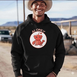 May include: Black hoodie with a kangaroo-lobster graphic inside a white circle, with the text "AI ONLY" above the graphic. The graphic is red with a white outline. The hoodie has a front pocket and a drawstring hood.