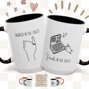 Könnte beinhalten: Zwei weiße Keramikbecher mit schwarzen Griffen und Rändern. Ein Becher zeigt eine Handillustration mit dem Text "ENGINEER IN THE STREETS". Der andere Becher hat eine Laptop-Grafik und den Text "freak IN THE SHEETS."