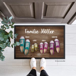 Könnte beinhalten: Eine rechteckige Fußmatte mit dunkler Holzmaserung, weißem Schriftzug "Familie Höller" und vier Paar bunten Canvas-Sneakern in verschiedenen Größen. Jedes Paar ist mit den Namen Jürgen, Lukas, Emilia und Christine beschriftet.