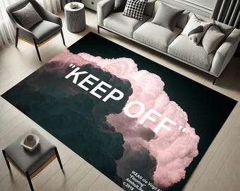 May include: A black and pink rug with a white cloud design and the text "KEEP OFF" printed on it. The rug also includes the text "IKEA® c/o Virgil Abloh™" and "Flooring" in white.