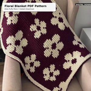 May include: A burgundy and cream-colored floral blanket. The blanket features a repeating pattern of cream-colored flowers against a burgundy background. The text "Floral Blanket PDF Pattern" is in the upper left corner.