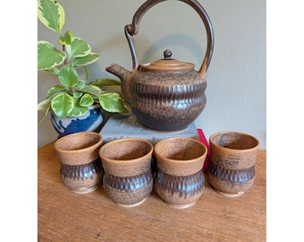 Vintage theeservies uit de jaren 70 van Studio Pottery: bruine theepot van steengoed en 4 geribbelde kopjes.