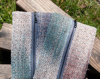 Estuche o bolsa con cremallera hecha a mano con sarga tejida a mano y tela remallada en azul, verde azulado y marrón.