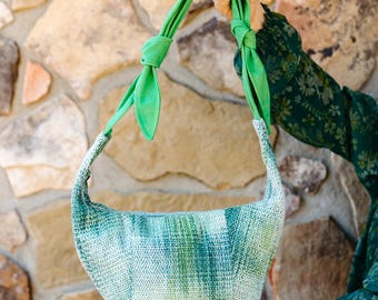 Bolso bandolera de sarga verde y gris claro tejido a mano, elaborado con fibras de cáñamo y lino