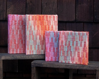 Cuadernos artesanales encuadernados en tonos naranjas.