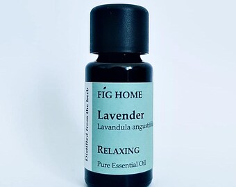 May include: A small, dark brown glass bottle with a black cap. The label is light blue and says "FIG HOME Lavender Lavandula angustifolia RELAXING Pure Essential Oil".
