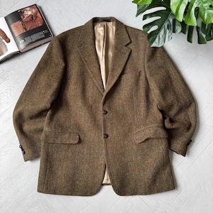 Peut inclure: Un blazer en tweed marron avec un motif à chevrons texturé, un revers cranté et deux boutons foncés sur le devant. La veste comprend deux poches à rabat à la taille, une poche poitrine et une doublure intérieure lisse de couleur beige clair.