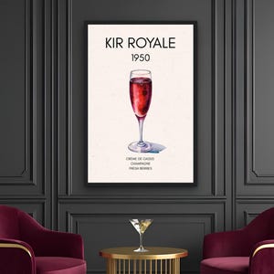 May include: A framed print of a Kir Royale cocktail, with the text "KIR ROYALE 1950". The print is above two burgundy velvet armchairs with gold legs. A gold side table with a martini glass sits between the chairs. The floor is black and white checkered.
