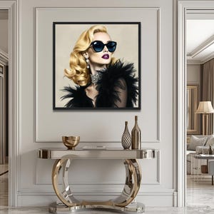 May include: A framed artwork depicts a woman with blonde hair, dark sunglasses, and a black feathered boa. The artwork hangs above a modern console table with a mirrored top and gold accents. Decorative bottles and a gold bowl are on the table.