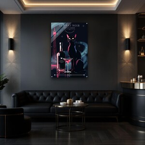 May include: A framed art print featuring a black cat, a bottle, and a martini glass. The print has a dark blue background with the Eiffel Tower in pink. The text "LE CHAT NOIR FRENCH LIQUEUR" is at the top.