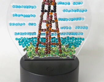 Lámpara de noche LED con forma de faro de Sanibel. Incluye pilas AA y mando a distancia para cambiar los colores. También tiene conexión USB.