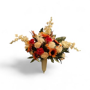 Op de afbeelding: Een levendig bloemstuk met zonnebloemen, rozen en andere bloemen in tinten rood, oranje en crème. Het boeket wordt gepresenteerd in een vaas met een lichtgroene tint, wat een visueel aantrekkelijke weergave creëert.