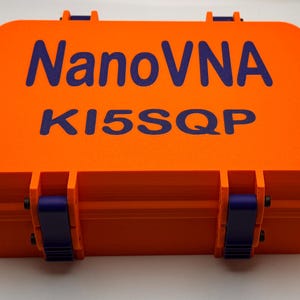 May include: Orange hard case with blue latches and the text "NanoVNA K15SQP" printed in blue.