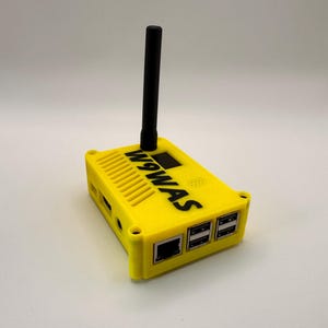 May include: A yellow electronic device with a black antenna and the text "W9WAS" printed on the side. The device has multiple ports and a small screen. The device is likely a radio or communication device.
