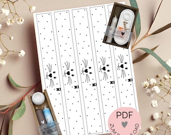 May include: A black and white PDF print template featuring a repeating pattern of bunny faces and polka dots. The image includes small wooden boxes with candles and a small plate. The text "PDF Druckvorlage" and "Zum Download" are visible.