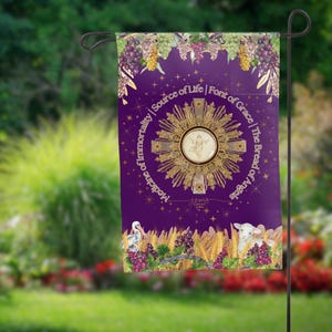 May include: Purple garden flag featuring a gold and white image of a monstrance, grapes, wheat, and a lamb. The text on the flag reads "Medicine of Immortality | Source of Life | Font of Grace | The Bread of Angels".