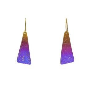 Könnte beinhalten: Ein Paar Ohrhänger mit dreieckigen Metallanhängern, die einen Farbverlauf von Gelb oben zu Violett und Blau unten aufweisen und mit einem dezenten, eingravierten geometrischen Muster über die gesamte Oberfläche versehen sind.