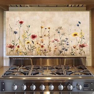 May include: A stainless steel gas cooker with six burners and a floral splashback featuring watercolour wildflowers in red, yellow, blue, and pink. The kitchen design includes wooden cabinetry.