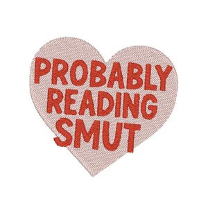 May include: A pink heart-shaped patch with the text "PROBABLY READING SMUT" in red embroidered lettering.