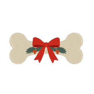 Puede incluir: Una forma de hueso de perro bordada en color crema claro con un lazo rojo brillante centrado en la parte delantera. El diseño incluye ramas de pino verde oscuro y pequeñas bayas naranjas detrás del lazo, creando un motivo festivo navideño.