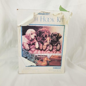 May include: A WonderArt latch hook kit featuring a design of three puppies. The box includes the text "Just Labs" and "45 Puppies". The approximate size is 24 x 34 inches.