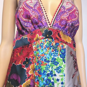 Peut inclure: Robe à col halter patchwork. Le haut présente un imprimé cachemire violet et rouge, tandis que la jupe arbore des motifs floraux rouges, bleus et blancs. La robe a un décolleté en V et un mélange de couleurs vives.