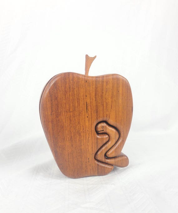 A hand-carved wooden apple with a snake-shaped hidden key mechanism — solving the secret compartment is half the fun, and the teacher gift angle is chef's kiss.