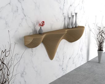 Può includere: Una moderna mensola sospesa in legno con un design ondulato unico. La mensola marrone chiaro contiene diversi vasi bianchi e un piccolo vaso con fiori rossi. Lo sfondo è un muro di marmo.