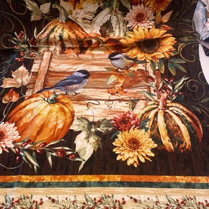 May include: A brown fabric with a fall theme featuring pumpkins, sunflowers, and birds. The fabric has a border with green leaves and red berries.