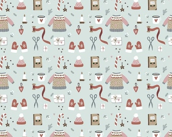 May include: A light blue fabric featuring a repeating pattern of winter-themed illustrations including sweaters, mittens, candy canes, candles, books, scissors, spools of ribbon, and gifts. A 12-inch ruler is visible at the bottom edge of the fabric.