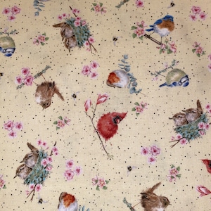 May include: A fabric with a repeating pattern of various birds, pink flowers, and small black dots on a light yellow background. The birds include robins, bluebirds, and a red cardinal, perched on branches with flowers and nests.